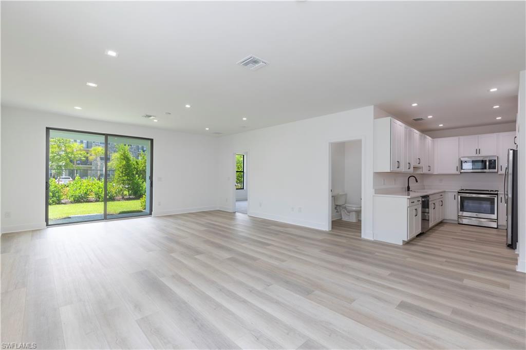 a view of kitchen with kitchen island wooden floors and living room