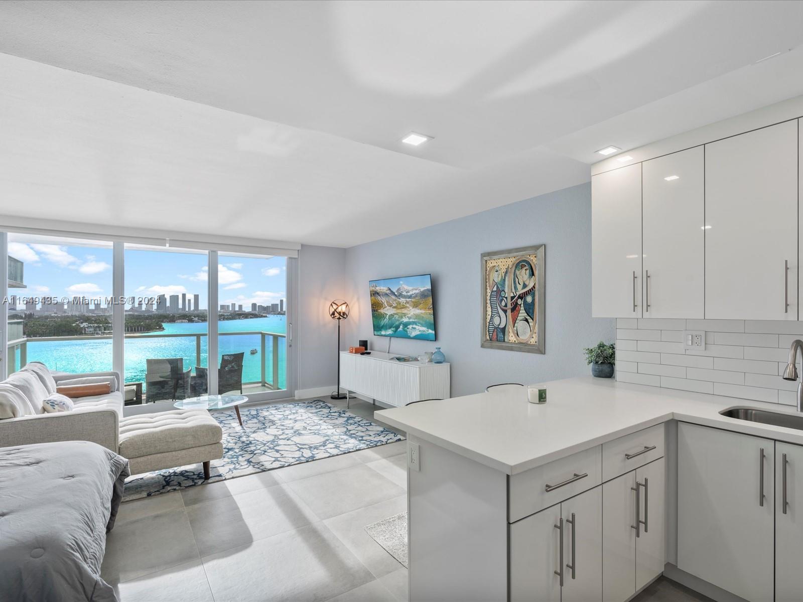 a living room with furniture a large window with kitchen view