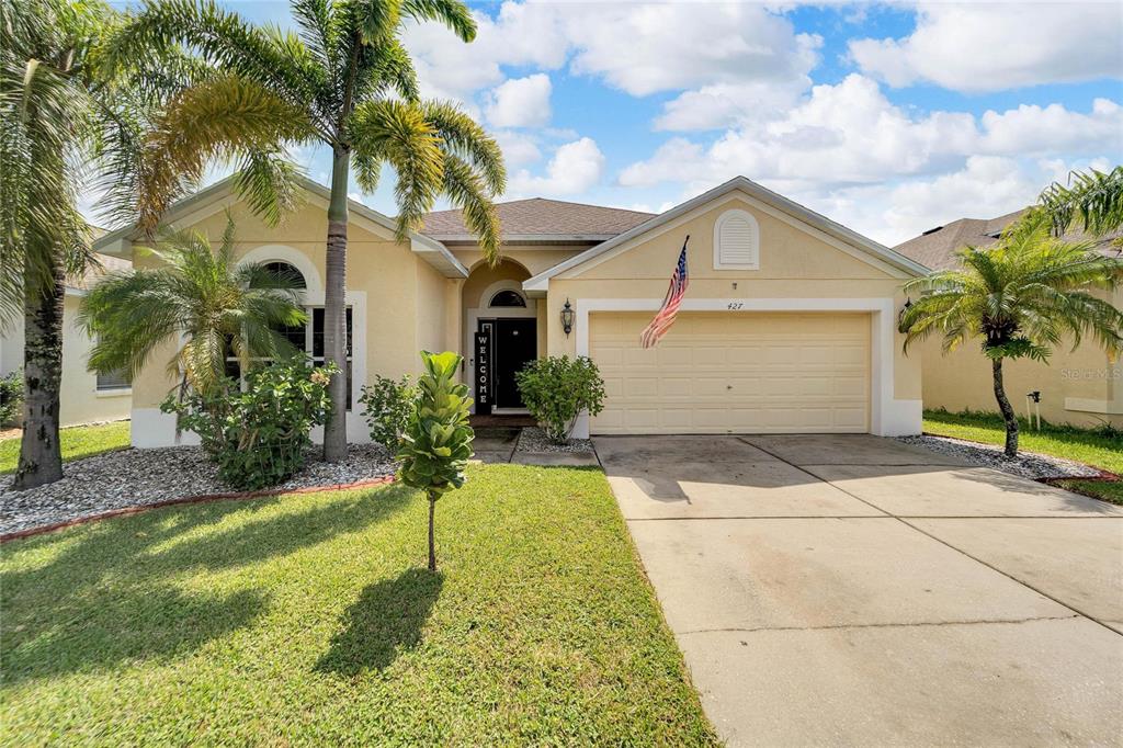 a front view of a house with a yard and garage