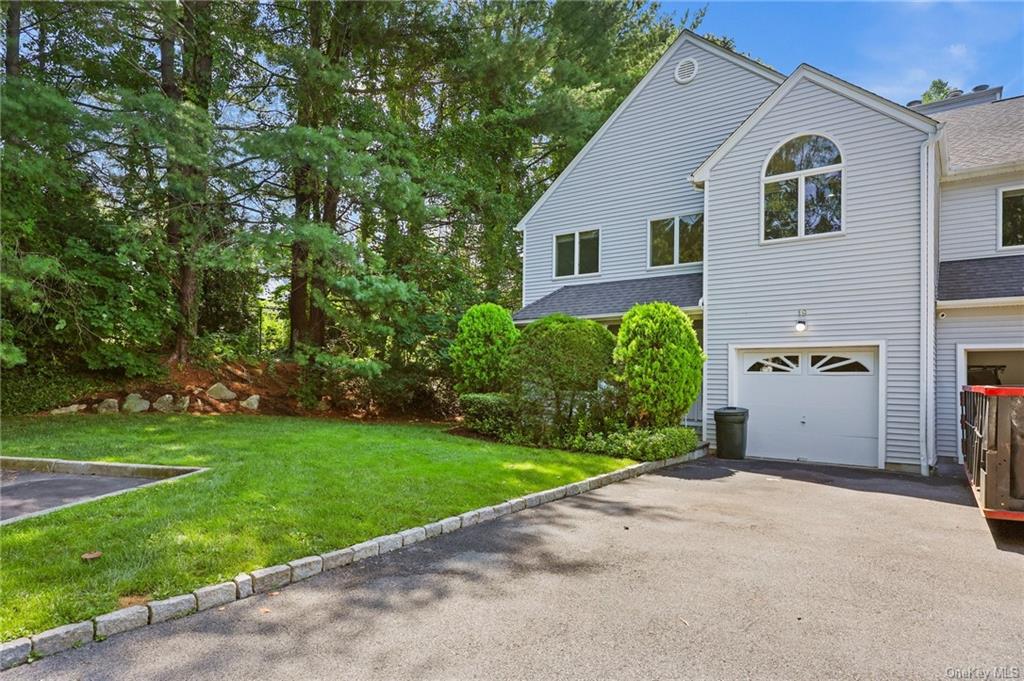 View of property exterior featuring a garage and a yard