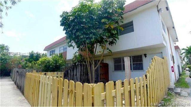 a view of a house with wooden fence