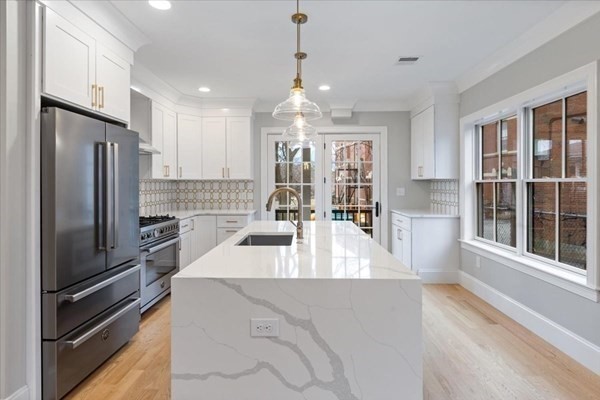 a view of a kitchen with refrigerator and large windows