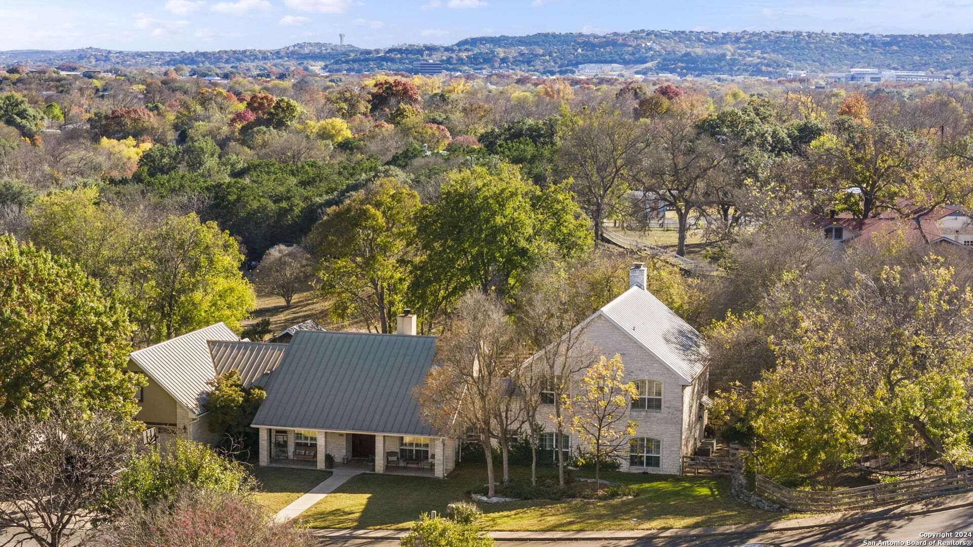 an aerial view of residential houses with outdoor space and trees