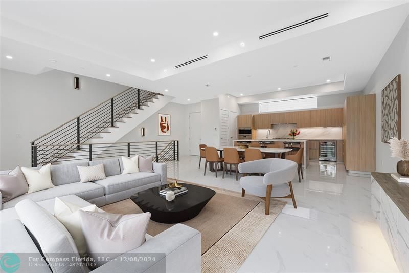 a living room with furniture and a view of kitchen