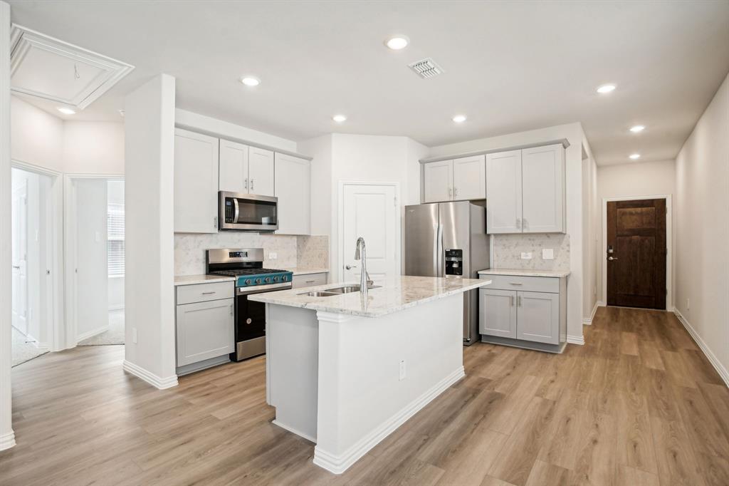 a kitchen with white cabinets and stainless steel appliances