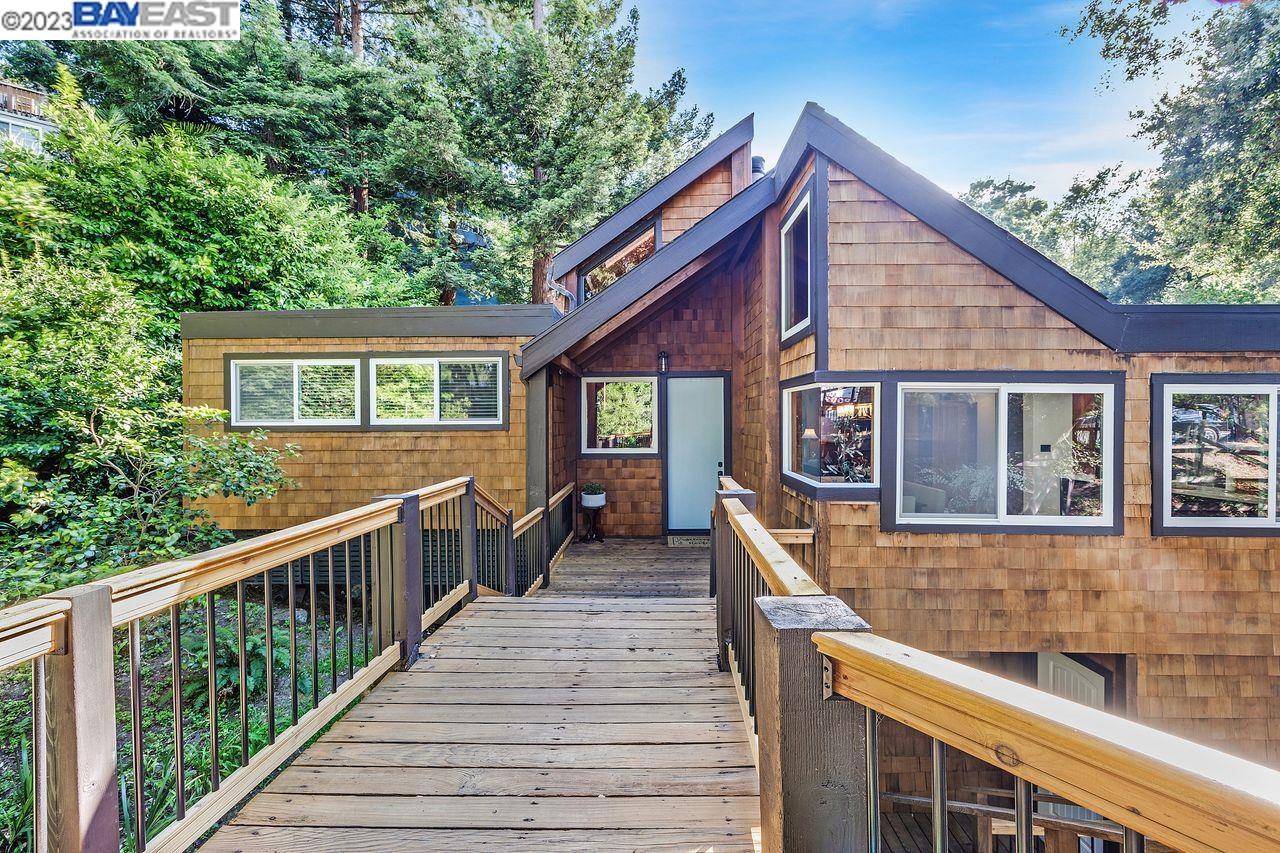 a view of a house with wooden deck and furniture