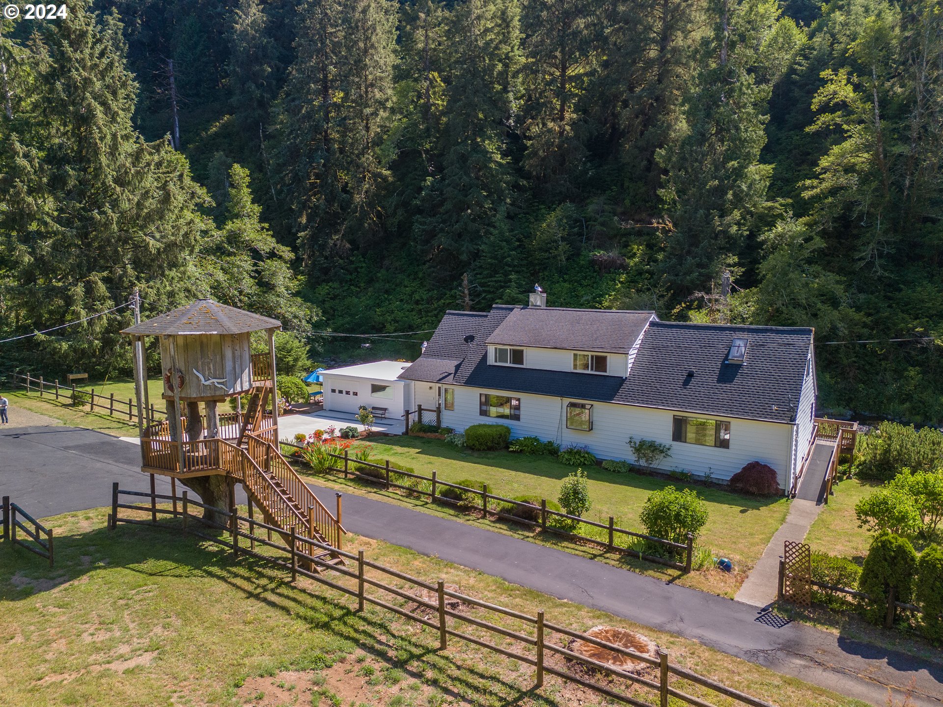 an aerial view of a house with garden space and trees