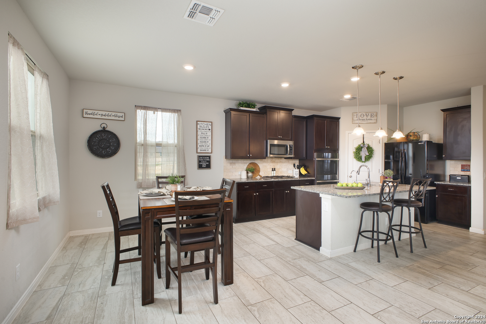 a kitchen with a dining table chairs and refrigerator