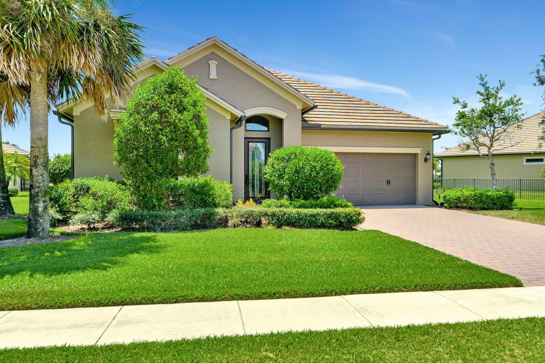 a front view of a house with a garden and plants