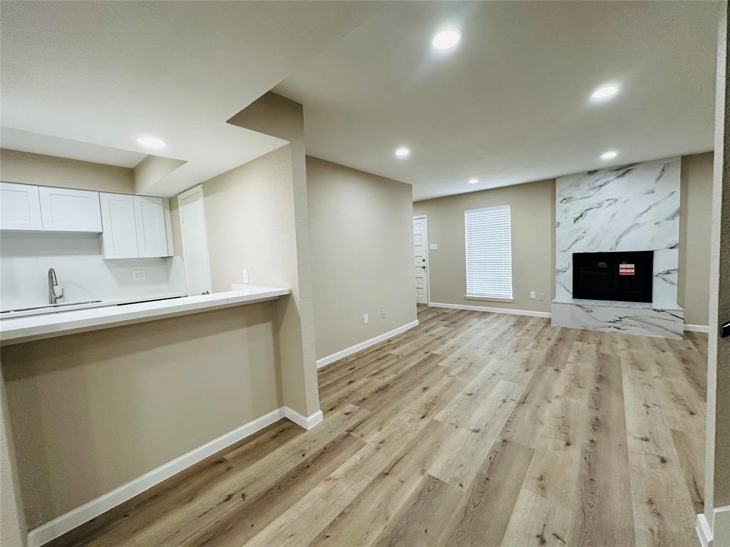 a view of empty room with wooden floor and fireplace