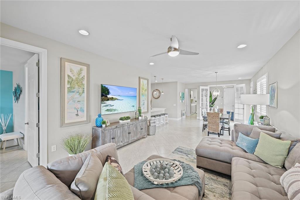 a living room with furniture kitchen view and a window