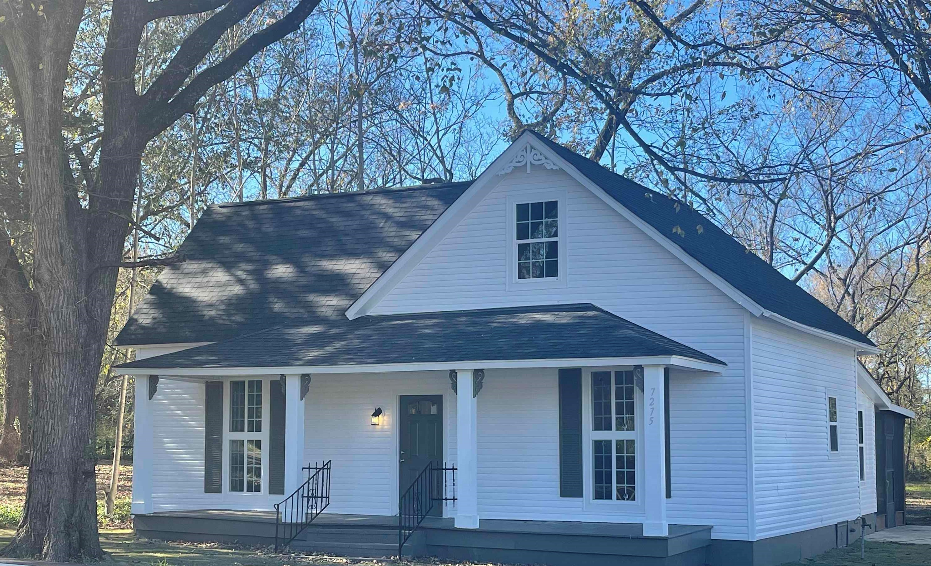 a front view of house with yard and trees around