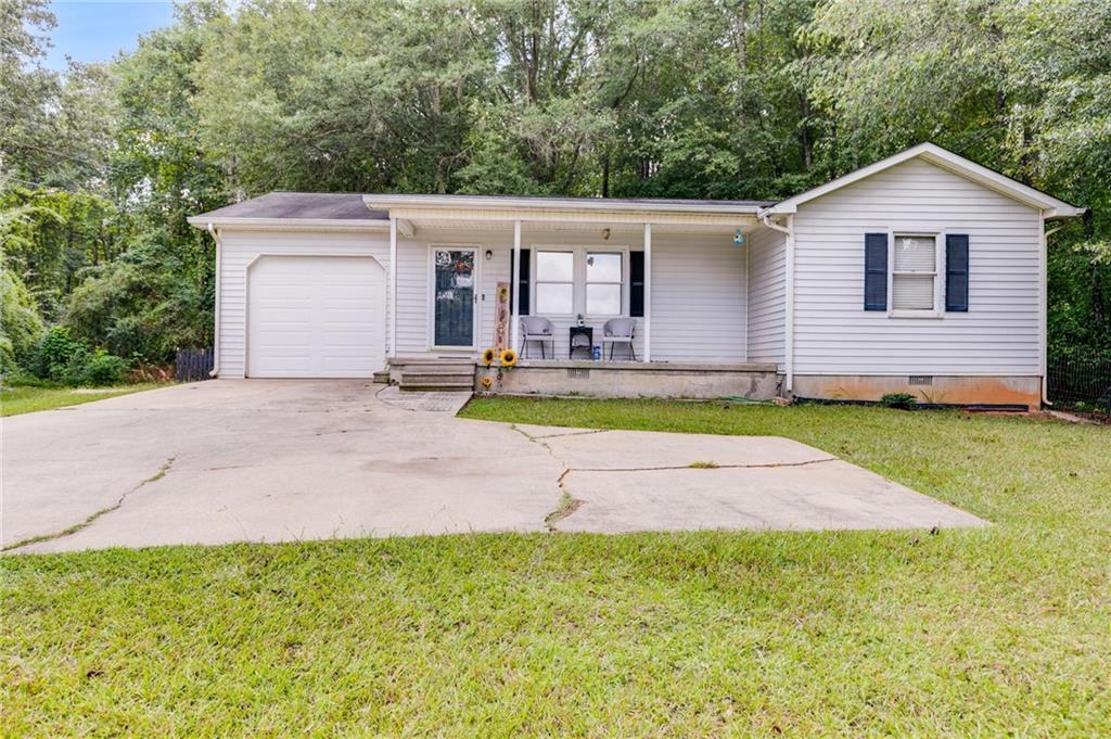 a view of a house with a yard and sitting area