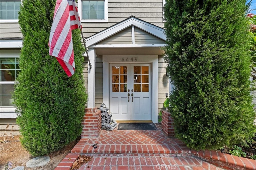 a front view of a house with plants