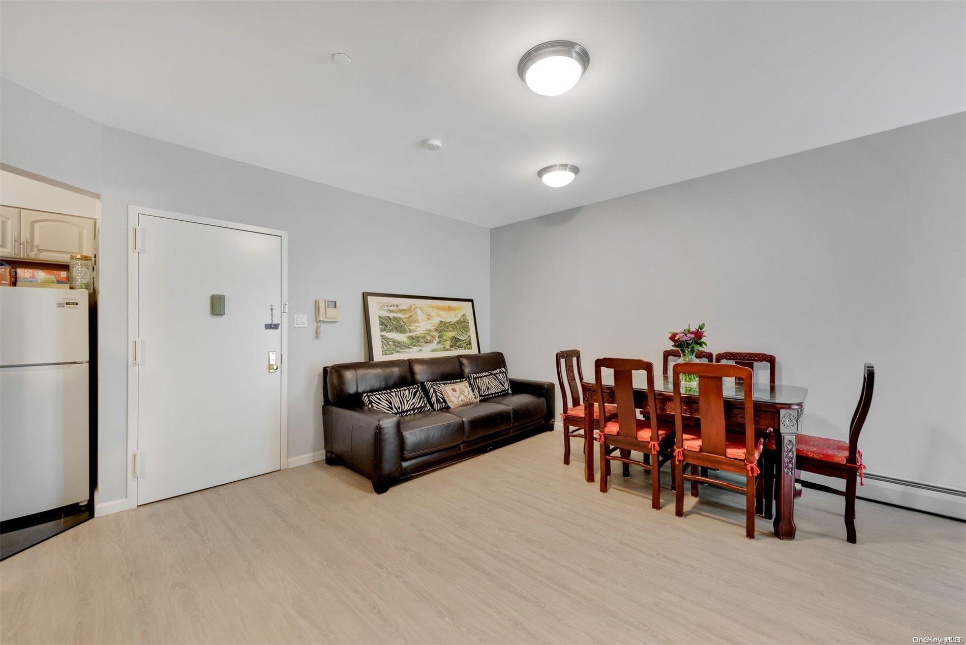 a living room with furniture and a dining table with wooden floor