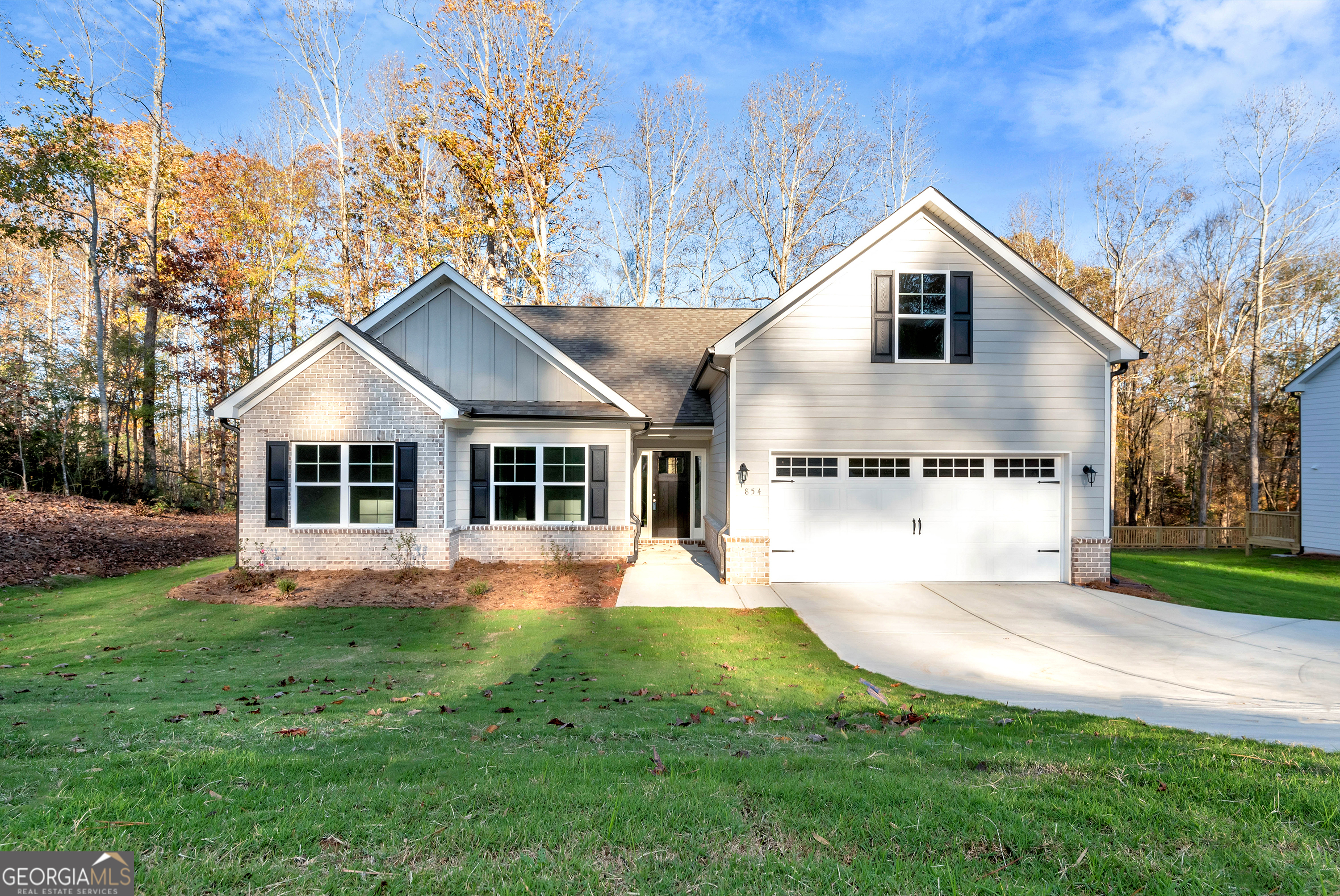 a front view of a house with a yard and trees