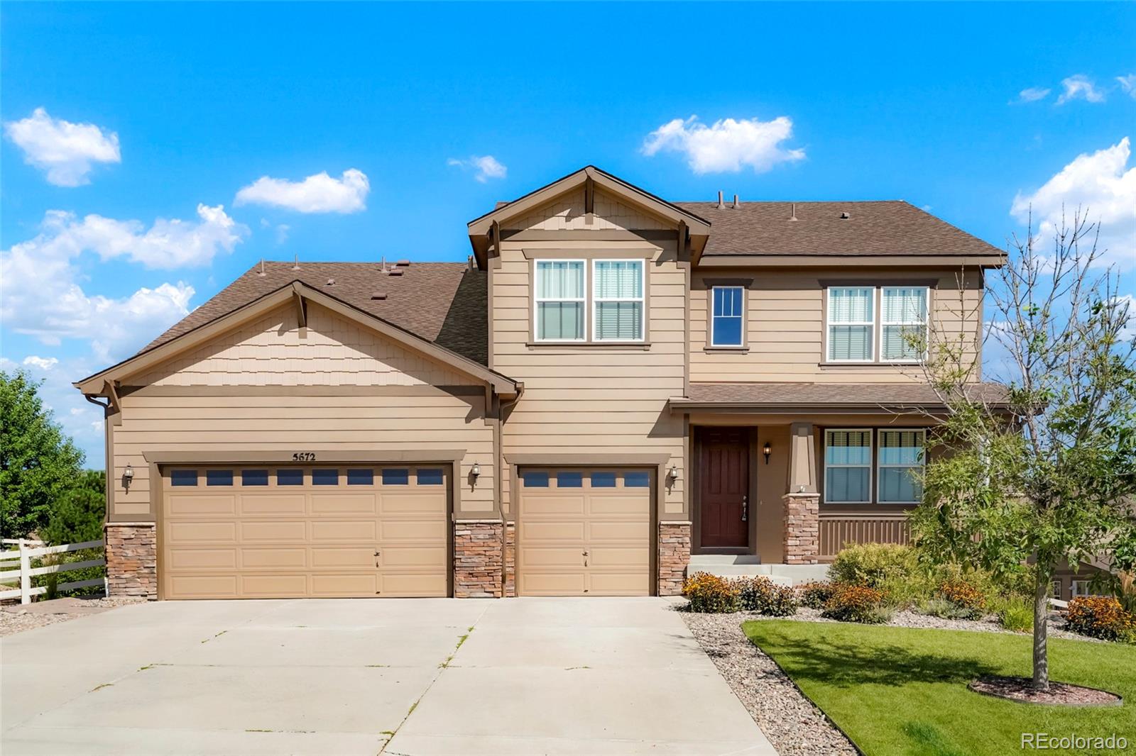 a front view of a house with yard and parking