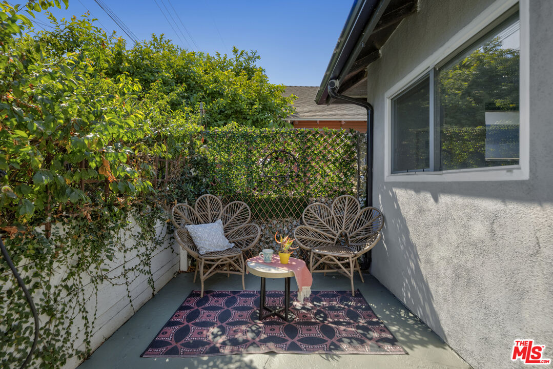 a view of balcony with couple of chairs and a potted plant