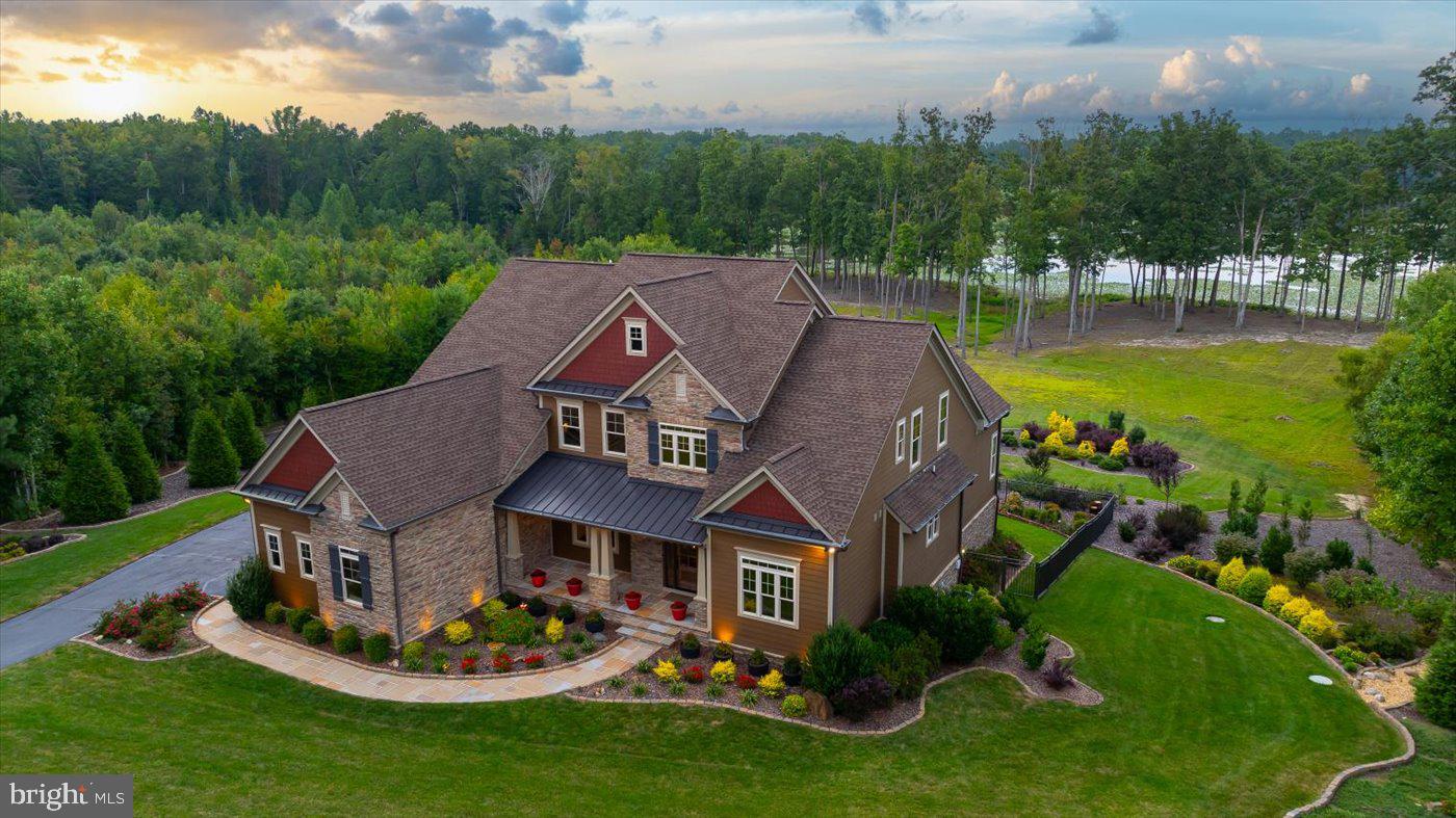 a aerial view of a house next to a big yard with plants and large trees