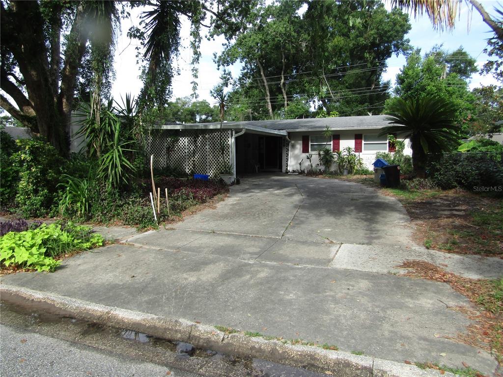 a view of a house with a yard and large trees