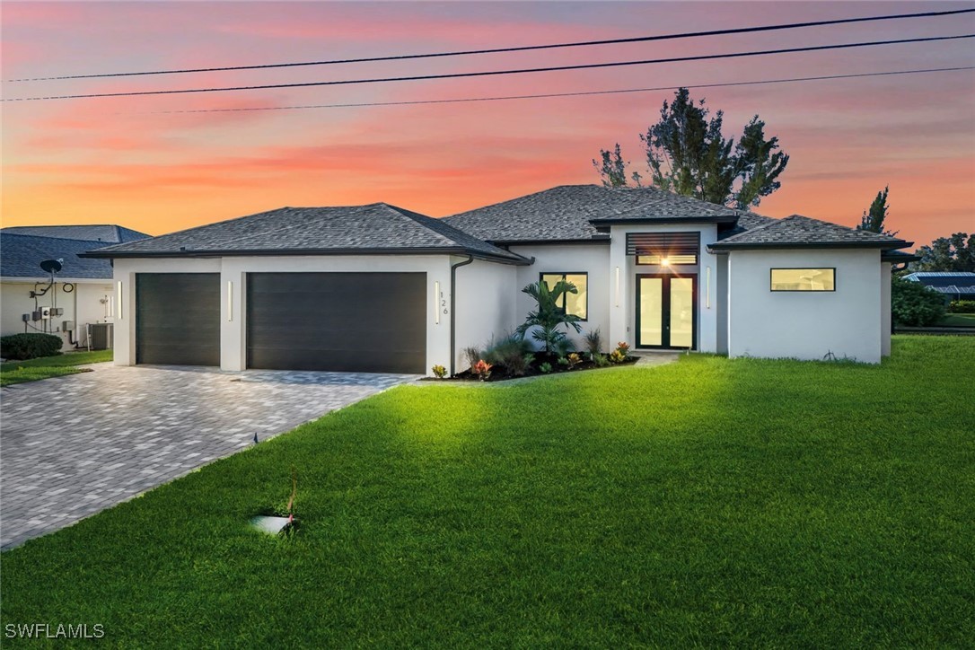 a front view of a house with a garden and yard