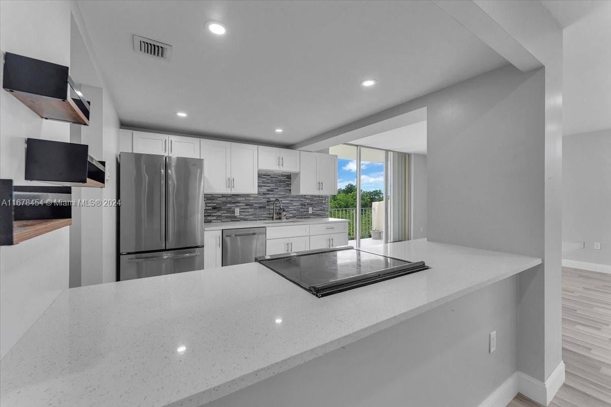 a kitchen with stainless steel appliances a refrigerator and a stove top oven