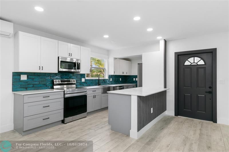 a kitchen with stainless steel appliances granite countertop a refrigerator and a stove top oven