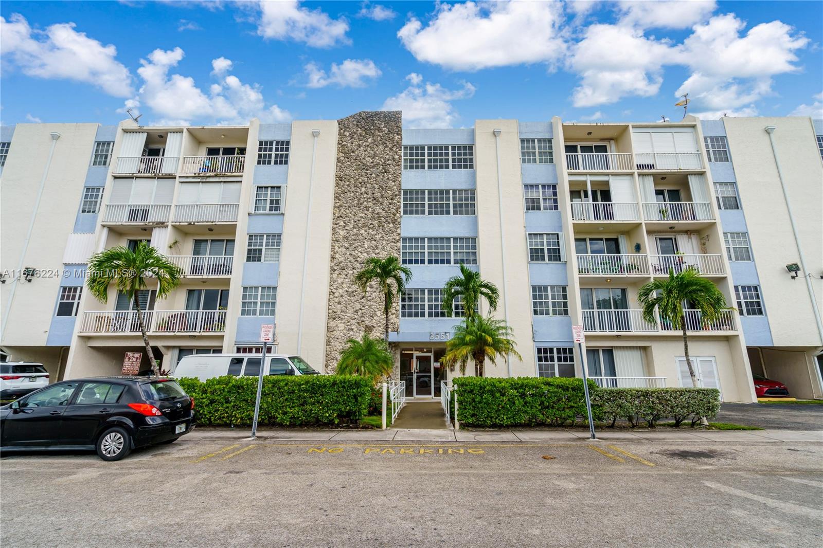 a front view of a residential apartment building with a yard