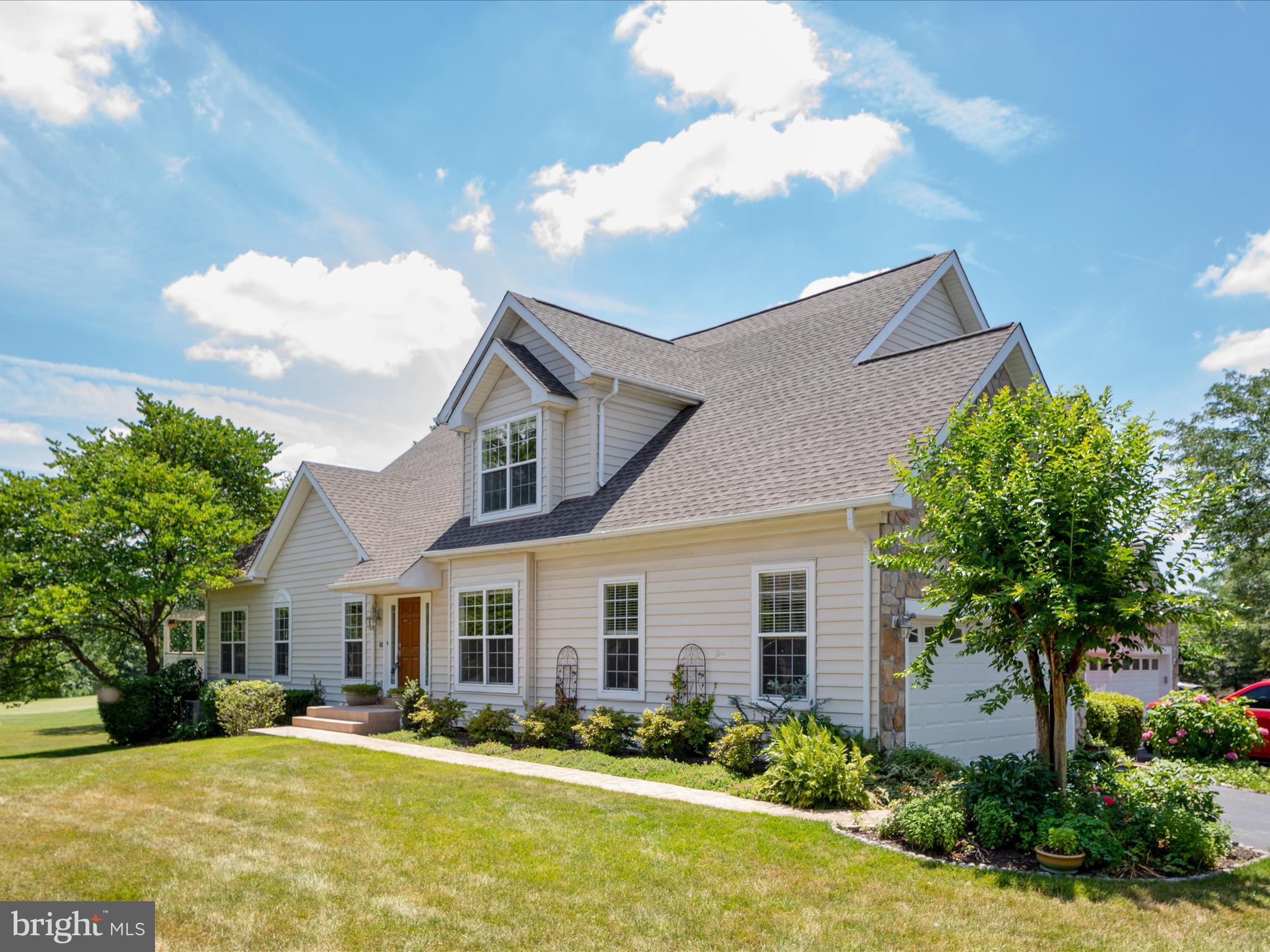 a front view of house with yard and trees in the background