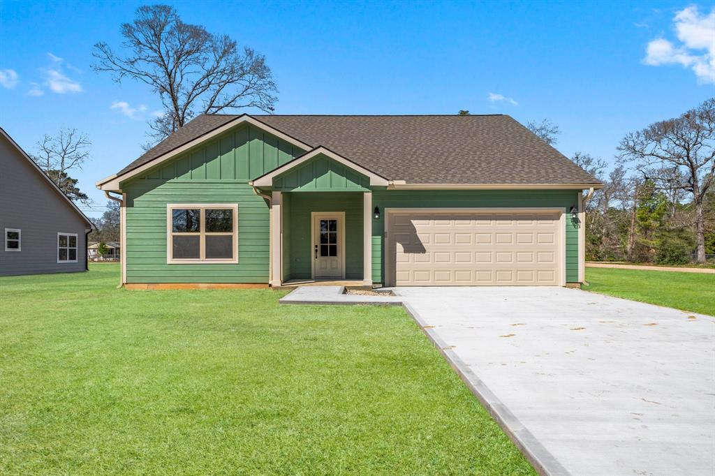 a front view of a house with a garden and yard