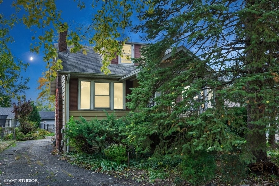 a front view of a house with a tree