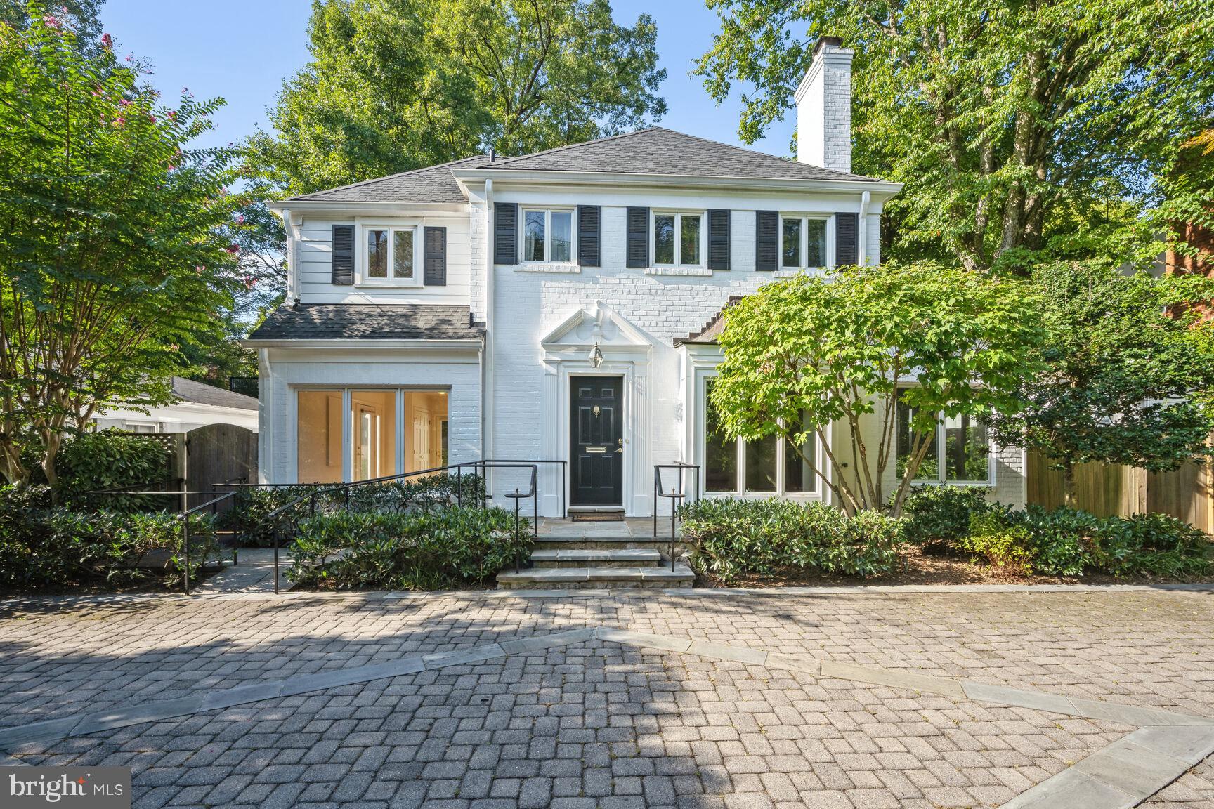 a front view of a house with yard and trees