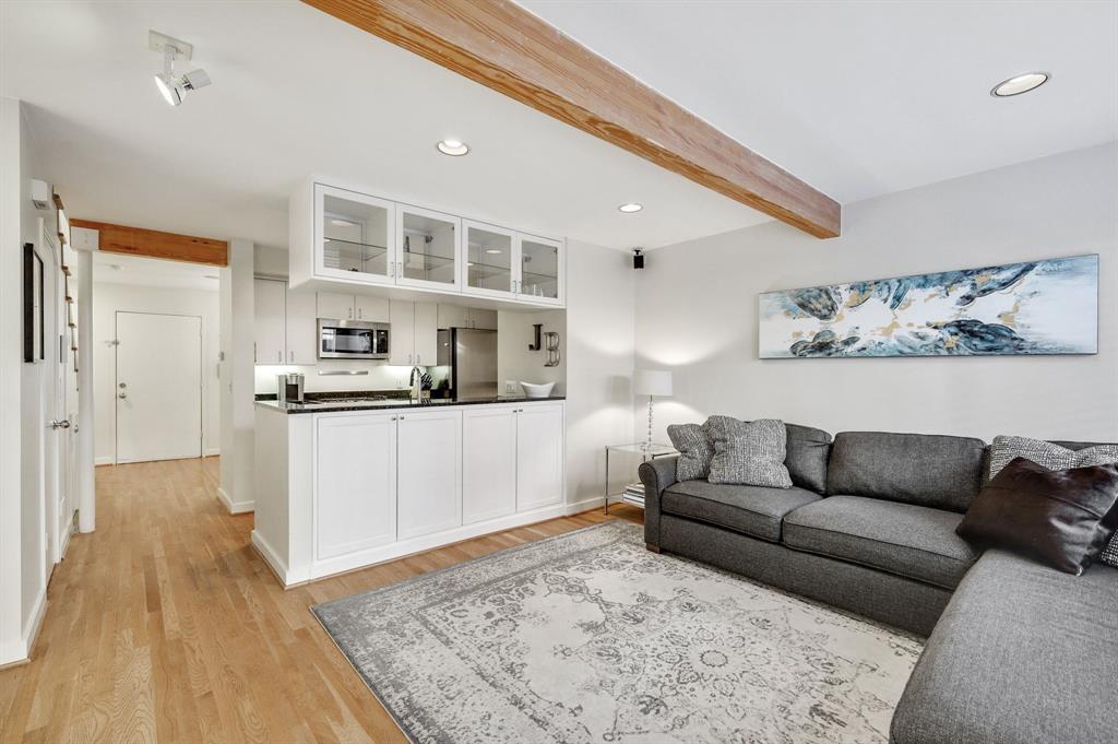 a living room with stainless steel appliances furniture and a kitchen view