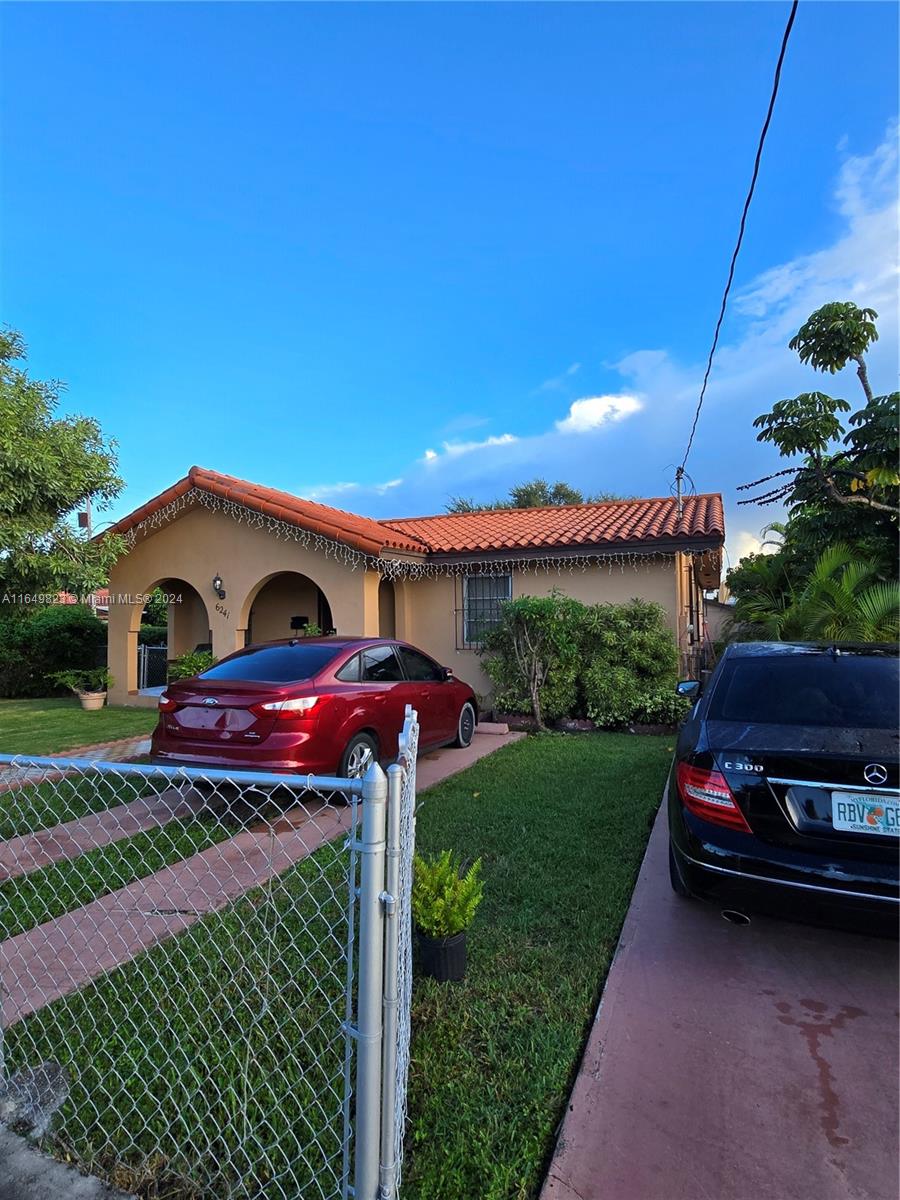 a front view of a house with a garden and parking space