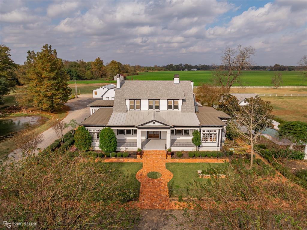 an aerial view of a house with a garden and lake view