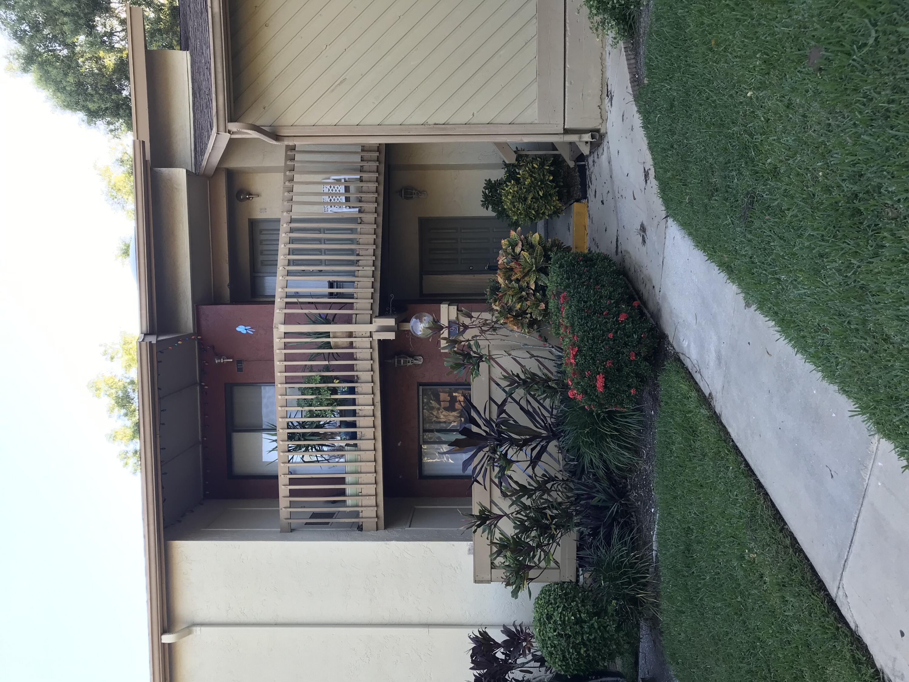 a view of backyard with potted plants and wooden fence