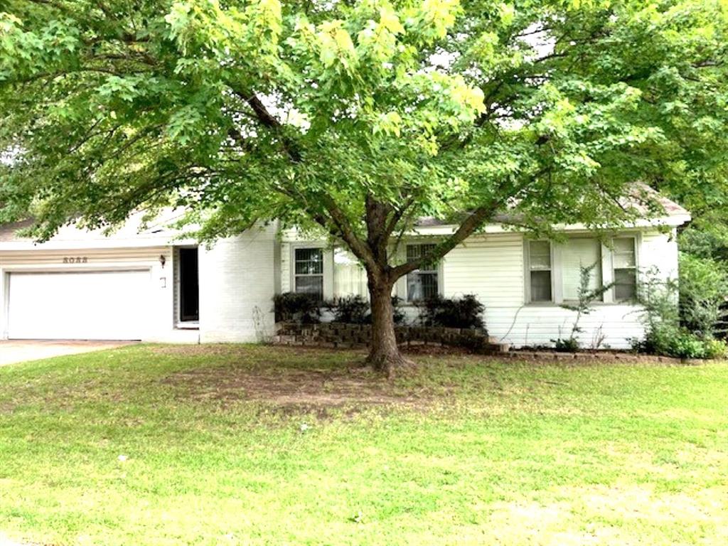 a view of a house with a patio and a yard