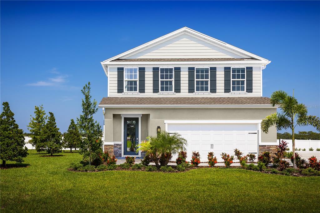 a front view of a house with a yard and tree