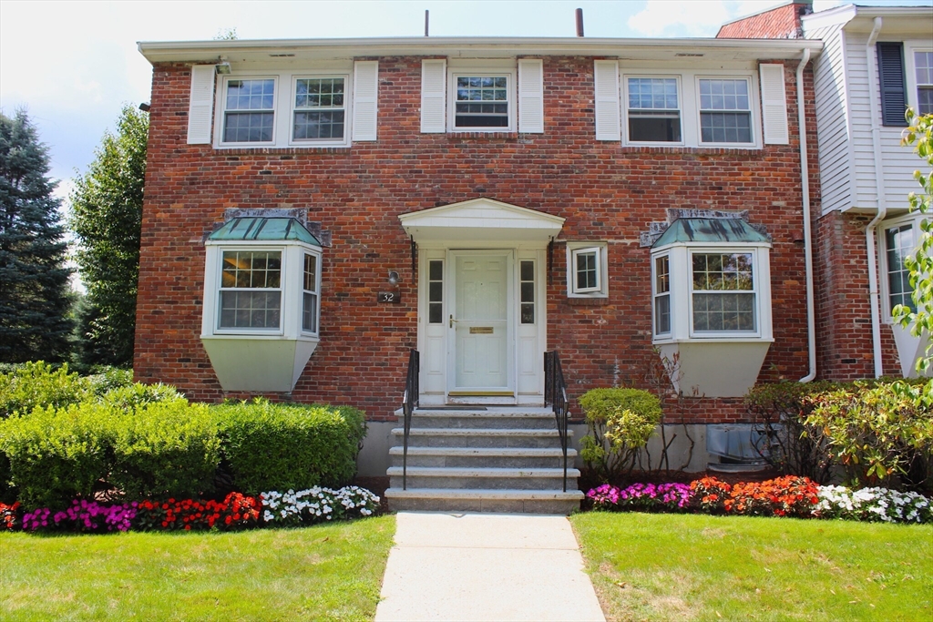 a front view of a house with a yard and fountain