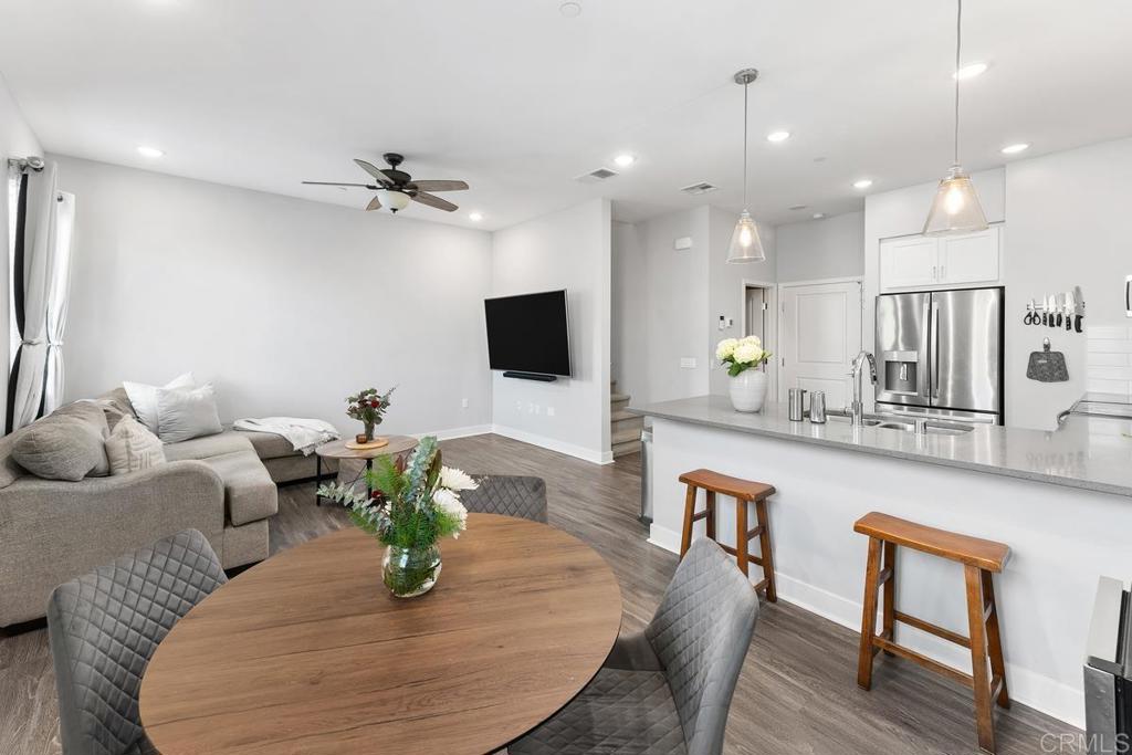 a living room with furniture a flat screen tv and kitchen view