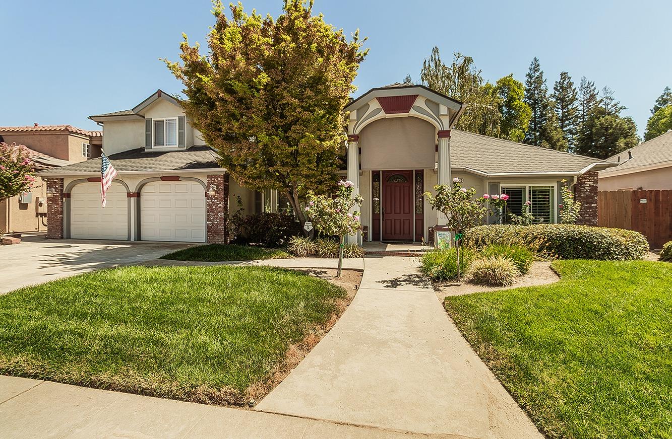 a front view of a house with a yard and potted plants