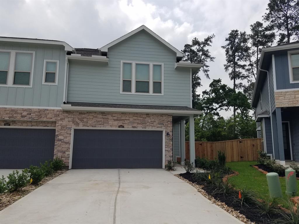 a front view of a house with yard and parking