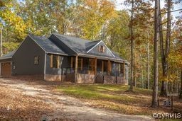 View of front of property with a porch and a garag