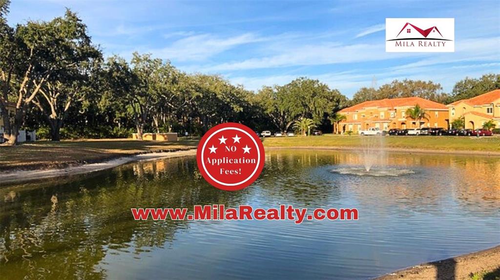 a view of swimming pool with a yard and lake view in the background