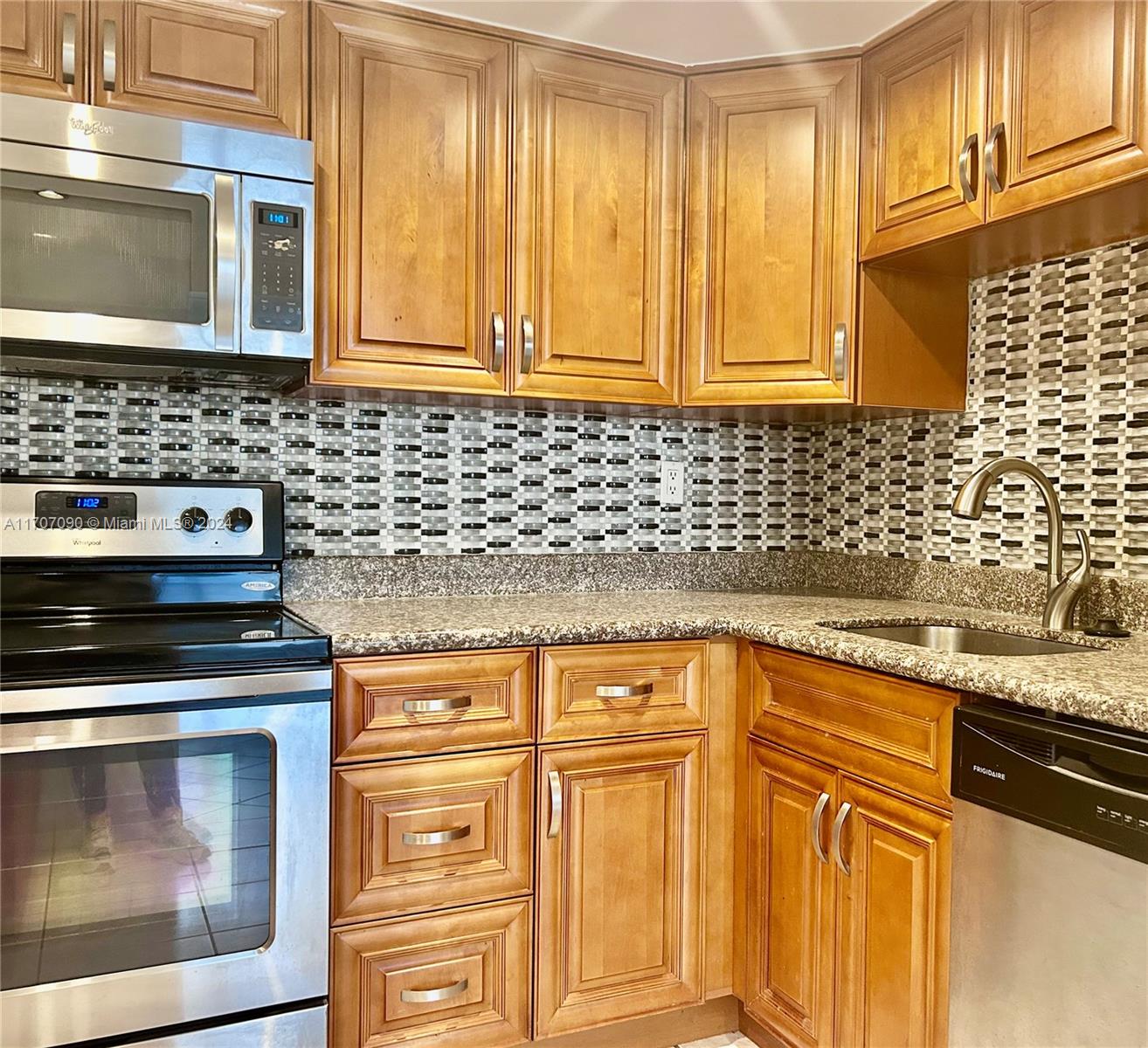 a kitchen with granite countertop cabinets stainless steel appliances and wooden cabinets