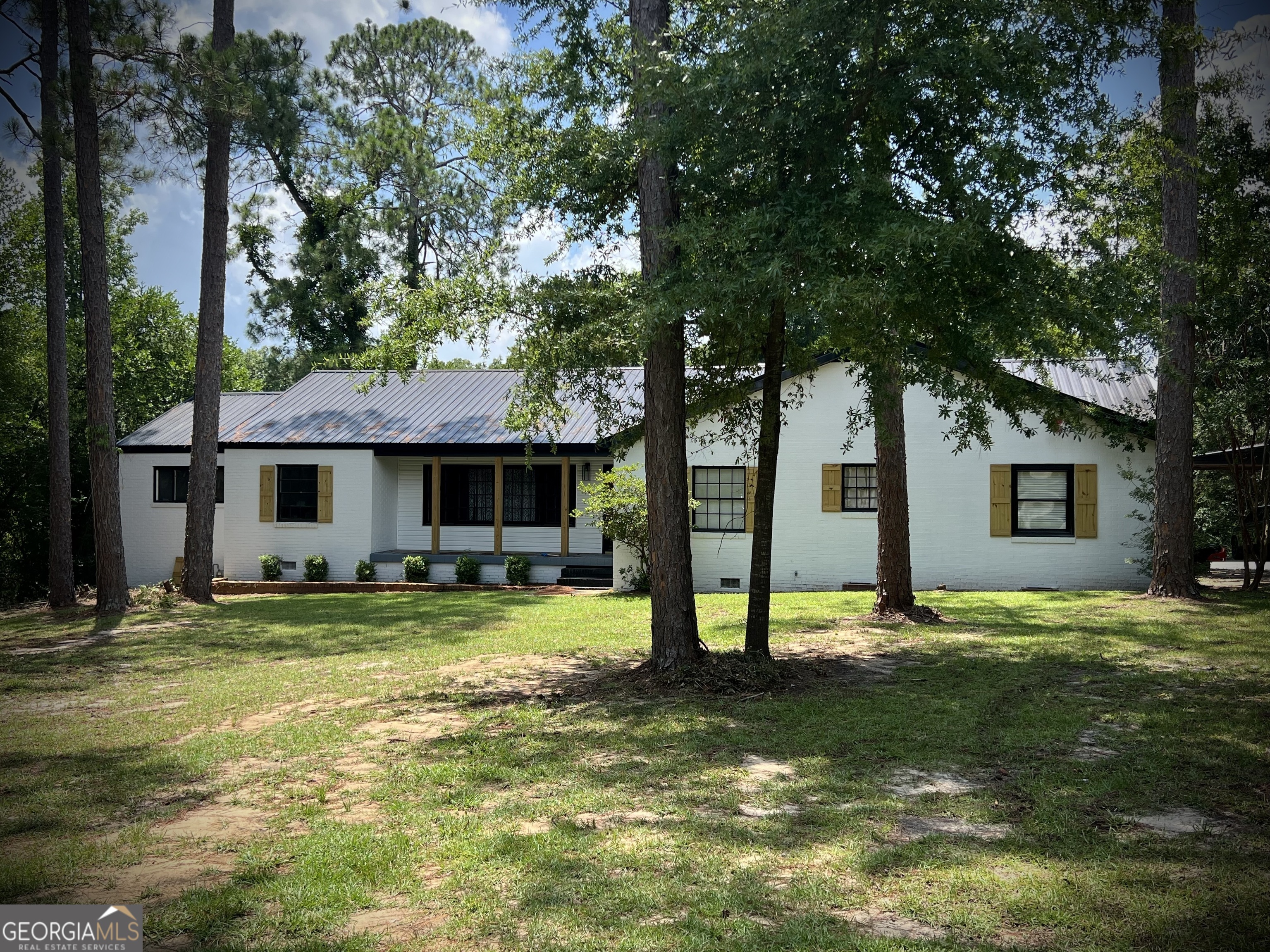 a view of a house with a big yard and a large tree