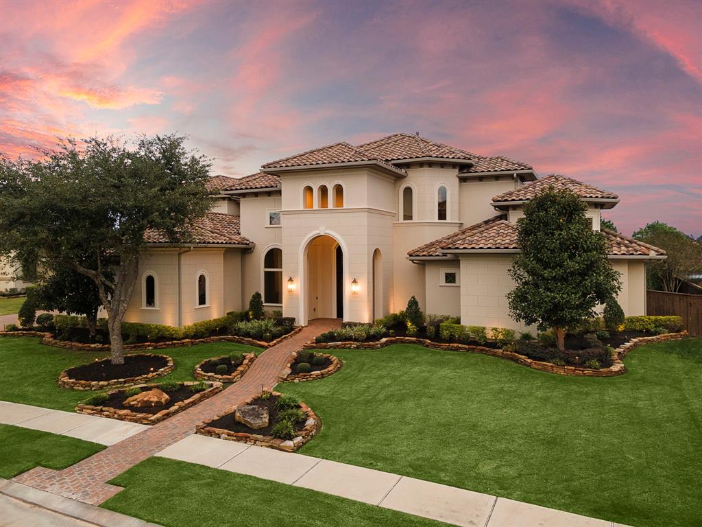 a view of a white house with a yard patio and a fire pit