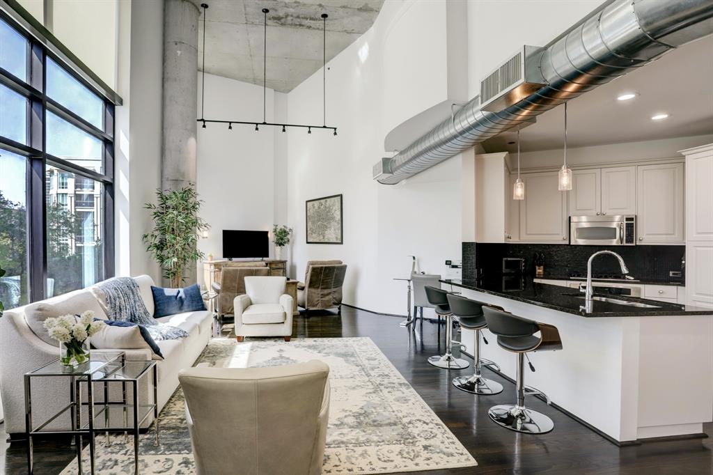 a living room with furniture a flat screen tv and windows