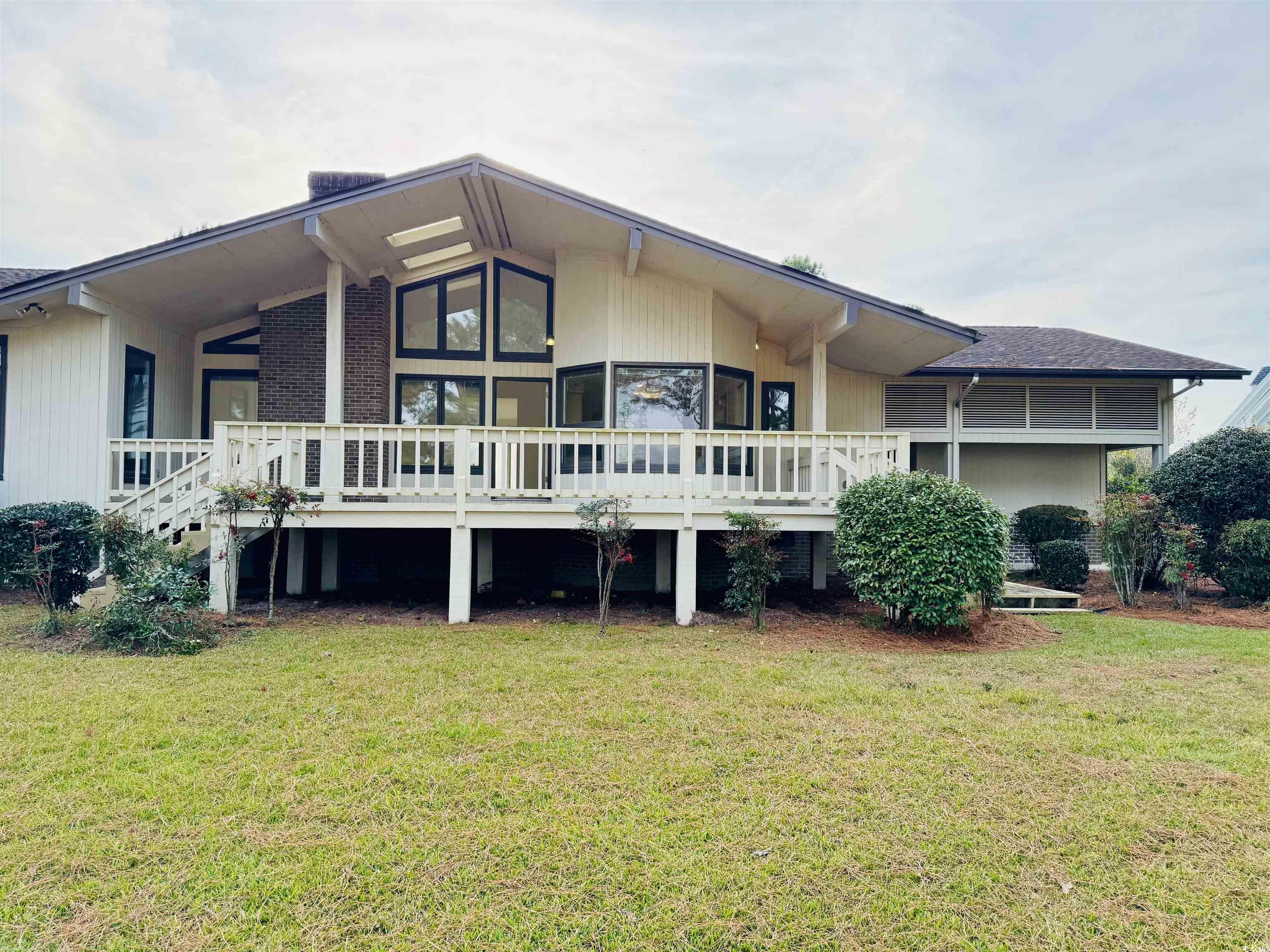 Rear view of property featuring a spacious yard an