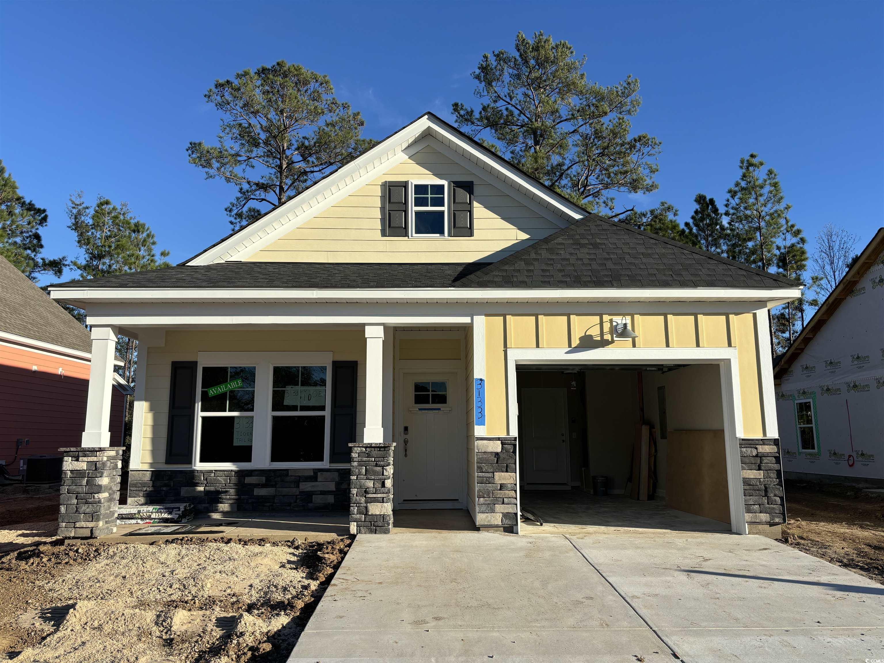 View of front of home featuring a porch and a gara